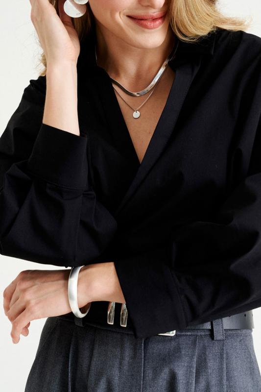 женщина в черной рубашке и элегантных серьгах